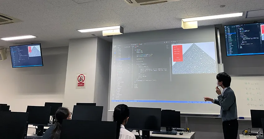 東3号館1階の演習室で総合課題の発表を行う筆者